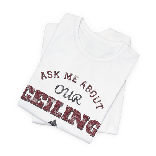 White folded crewneck T-shirt with 'ASK ME ABOUT OUR CEILING' graphic