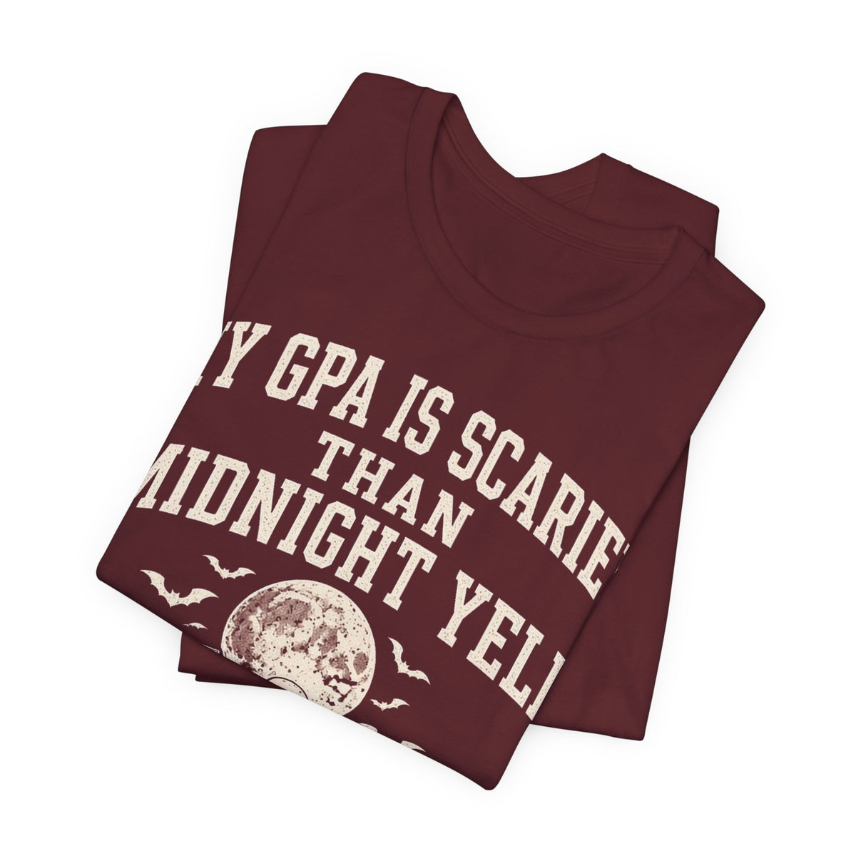 Maroon graphic T-shirt with large arched “GPA is scarier” and “Midnight yell” text