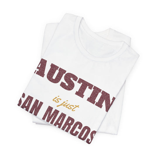 White T-shirt folded close-up with large 'AUSTIN' and 'SAN MARCOS' lettering