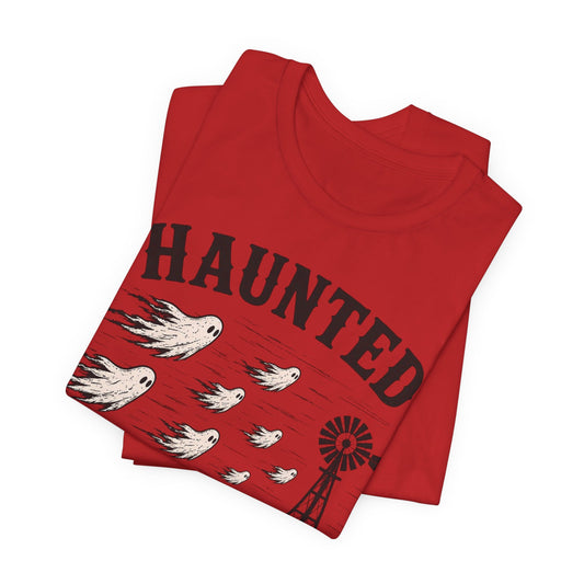Red T-shirt folded with Haunted Lubbock Wind graphic, birds and windmill front