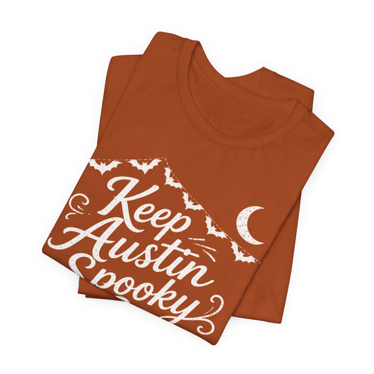 Rust orange crewneck T-shirt stacked view with white "Keep Austin Spooky" print