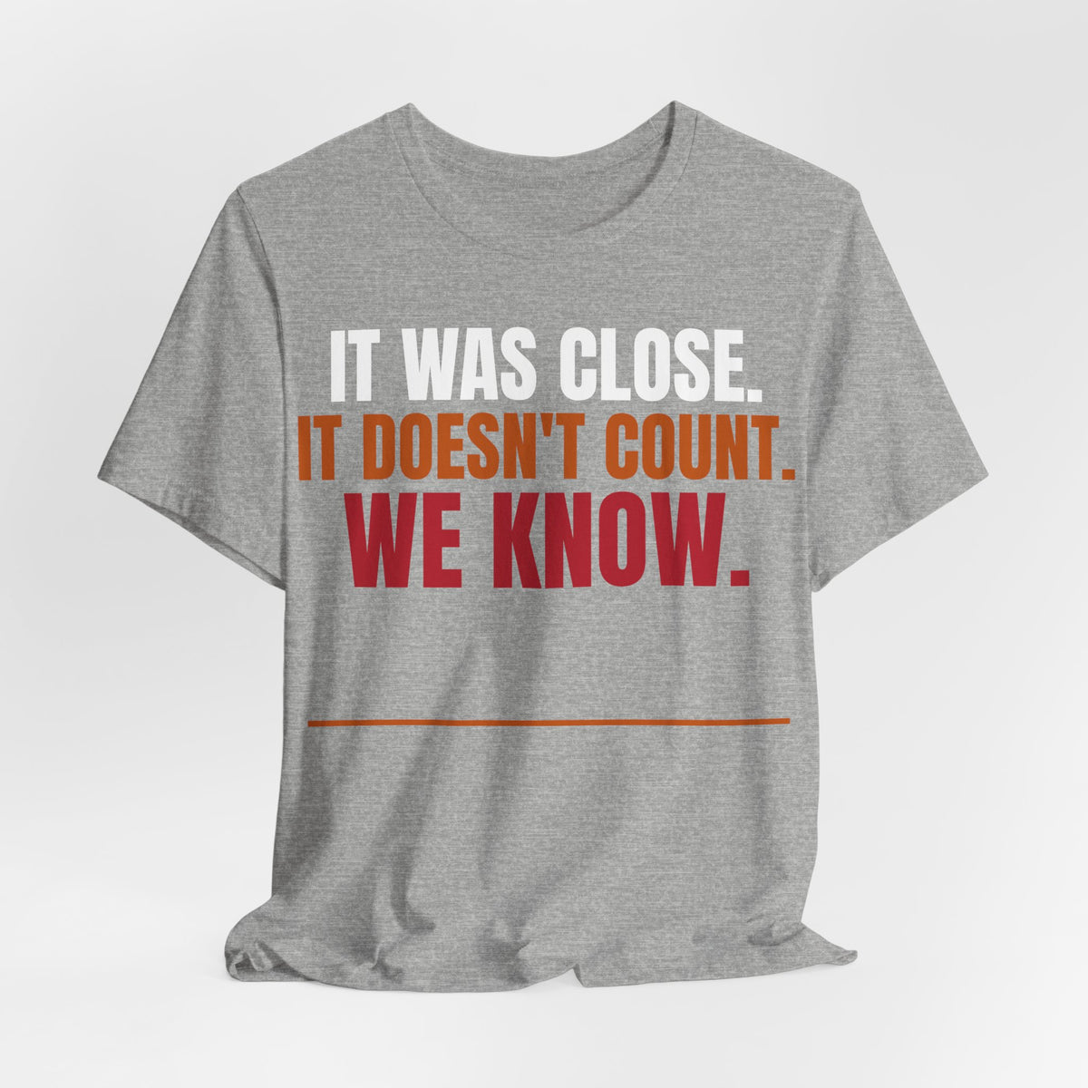 Athletic heather graphic tee with "IT WAS CLOSE" text in orange and red