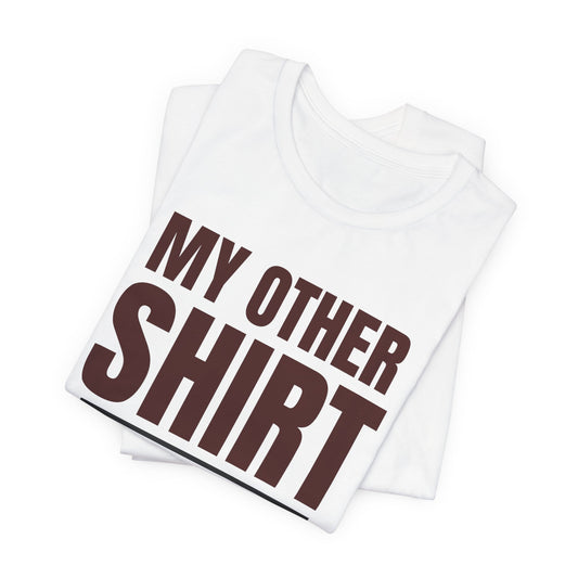 Folded white crewneck T-shirt with large maroon “MY OTHER SHIRT” text graphic.