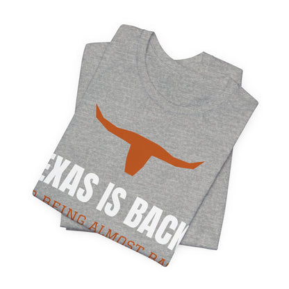 Athletic heather graphic tee showing 'Texas Is Back*' text and orange longhorn