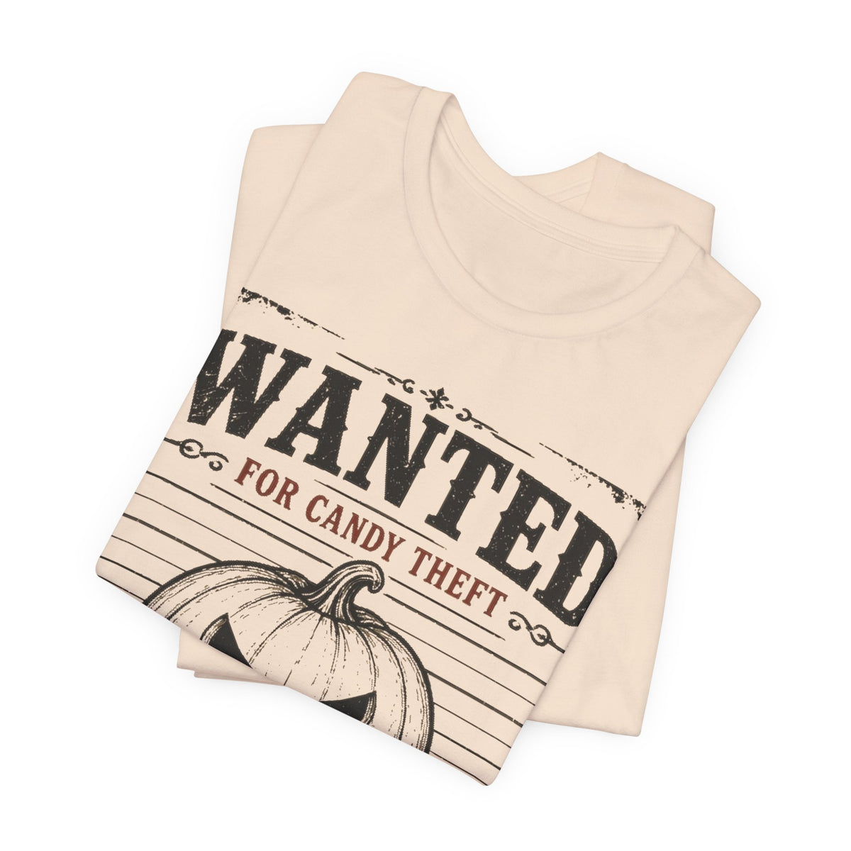 Soft cream tee with large black “WANTED” text and jack-o-lantern print
