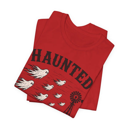 Red T-shirt folded with Haunted Lubbock Wind graphic, birds and windmill front