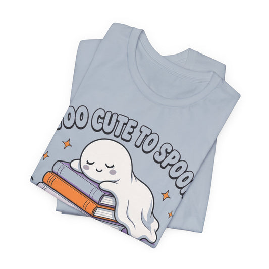 Light blue tee in flat lay, featuring smiling ghost cuddling stacked books print