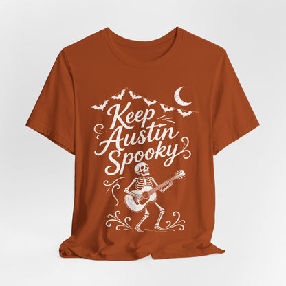 Rust orange crewneck tee featuring white "Keep Austin Spooky" skeleton with guitar
