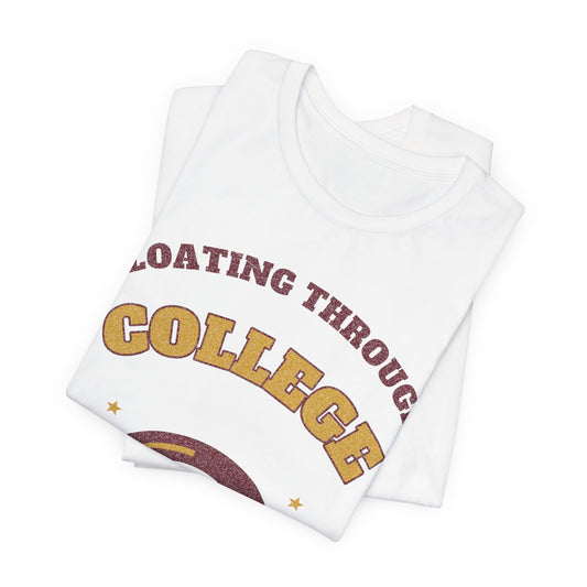 White T-shirt folded stack, “Floating Through College” arched text and donut-ring graphic