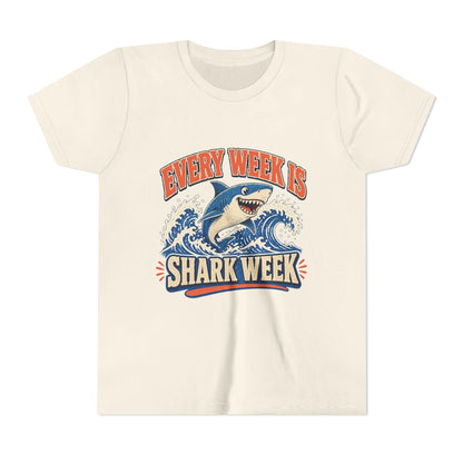Kids graphic T-shirt, natural, front with blue shark and “Shark Week” slogan