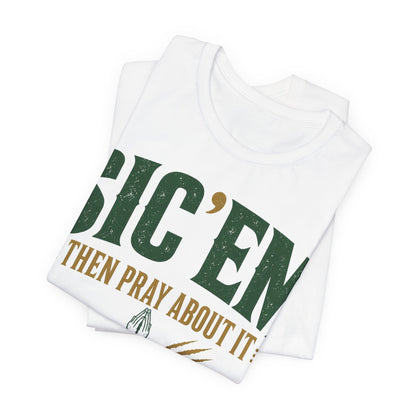 White folded tee stack with large diagonal 'SIC 'EM' text and prayer slogan