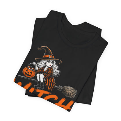 Black crewneck graphic tee with witch holding a jack-o’-lantern and orange text