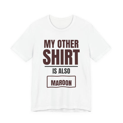 White crewneck T-shirt with maroon text graphic: “MY OTHER SHIRT IS ALSO MAROON”.