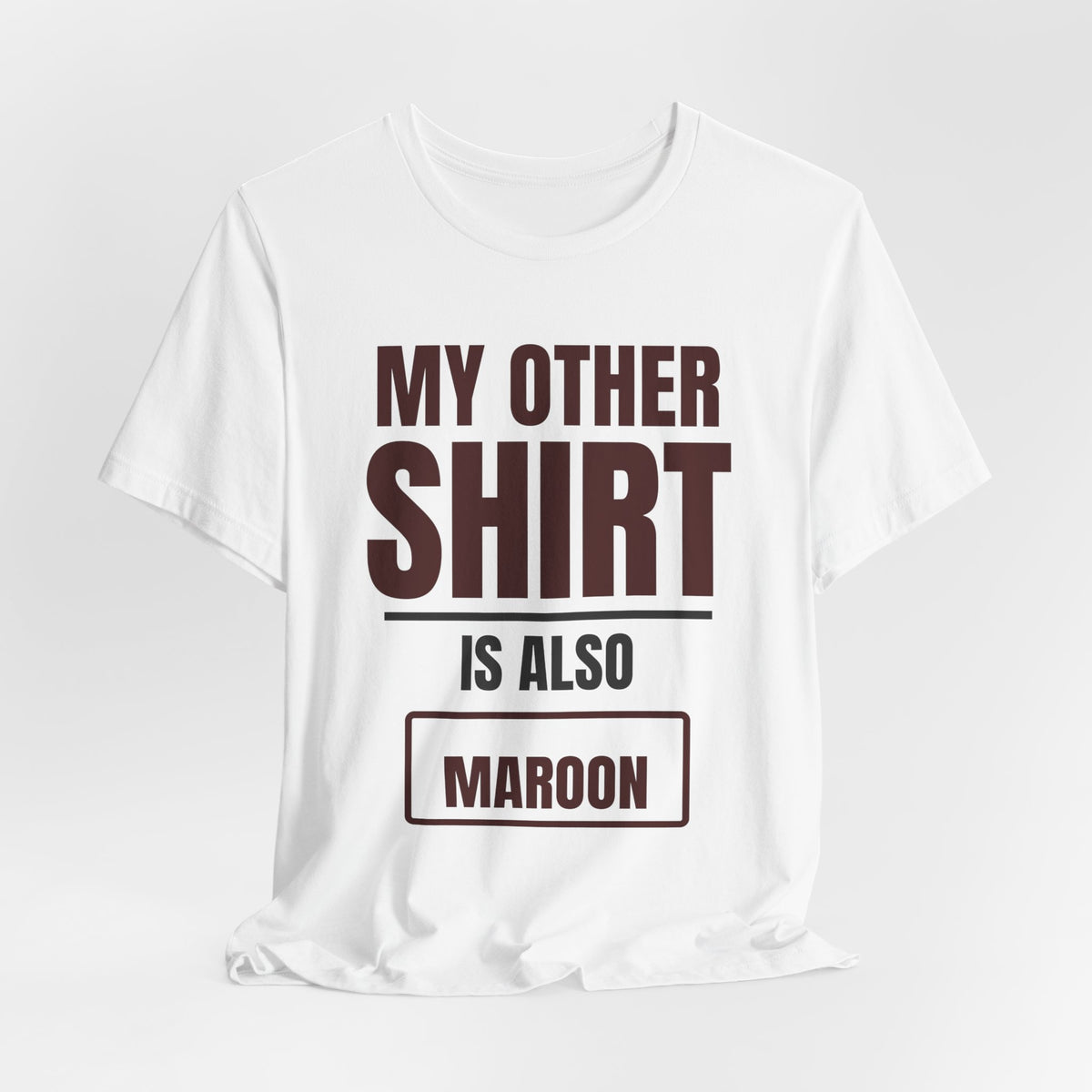 White crewneck T-shirt with maroon “MY OTHER SHIRT IS ALSO MAROON” front graphic.
