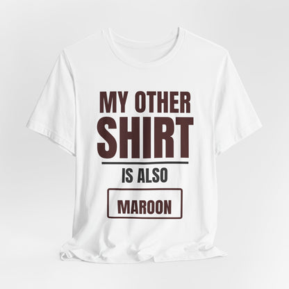 White crewneck T-shirt with maroon “MY OTHER SHIRT IS ALSO MAROON” front graphic.