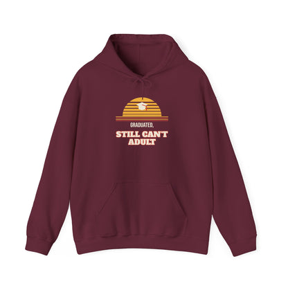 Maroon pullover hoodie with “Graduated” and “Still Can’t Adult” chest graphic
