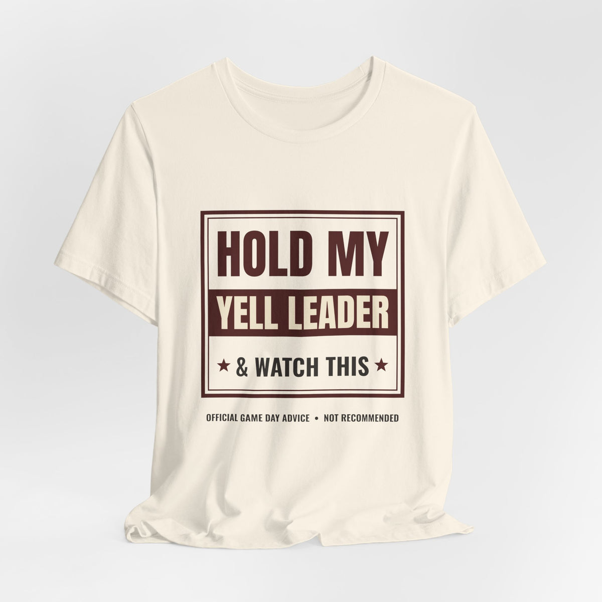 Natural crewneck graphic tee with "HOLD MY YELL LEADER" front print and knotted hem