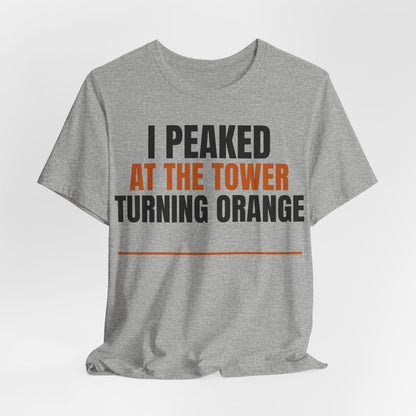Heather gray crewneck T-shirt with orange and black 'I PEAKED AT THE TOWER TURNING ORANGE' print.