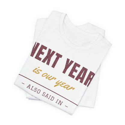 Folded white tee showing 'NEXT YEAR is our year' and 'ALSO SAID IN' text