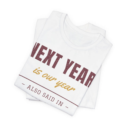 Folded white tee showing 'NEXT YEAR is our year' and 'ALSO SAID IN' text